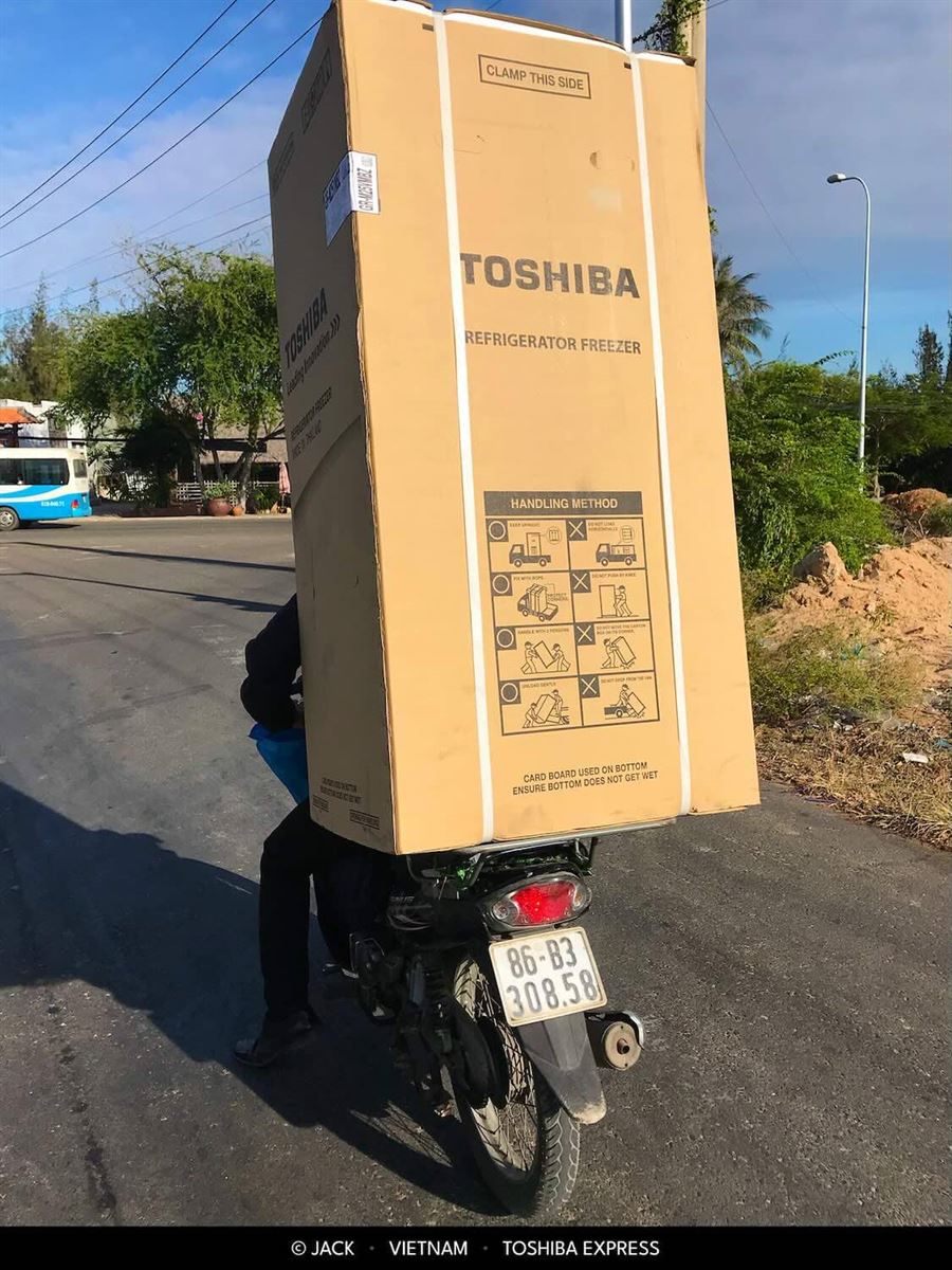Motorka veze obří krabici s ledničkou ve Vietnamu